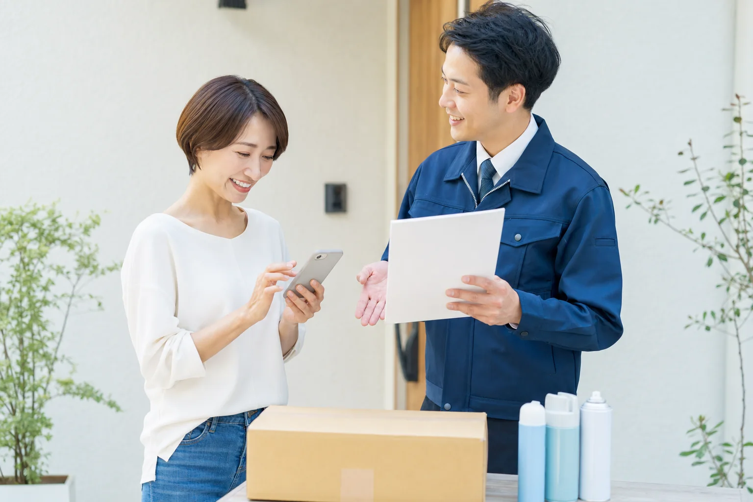スマートフォンと案内書を見ながら宅配回収を相談するお客様とスタッフ