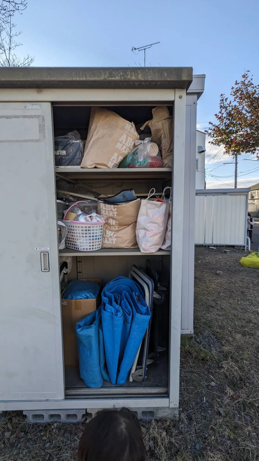 荷物が棚いっぱいに残っている物置内部