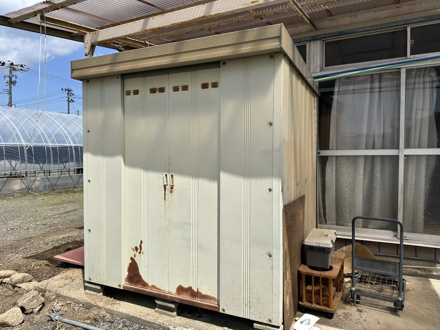 扉下部にサビが進んだスチール物置正面