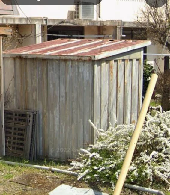 屋根全体にサビが広がった古い物置